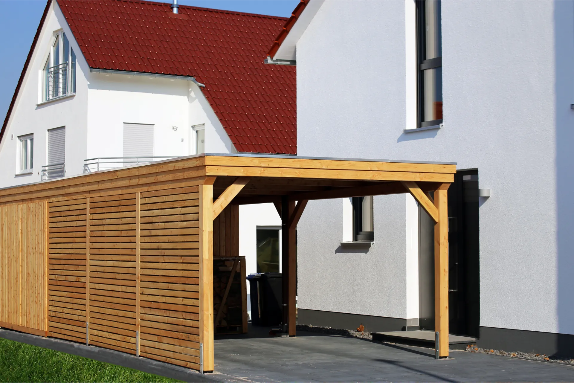 Carport i træ bygget op ad husets gavl